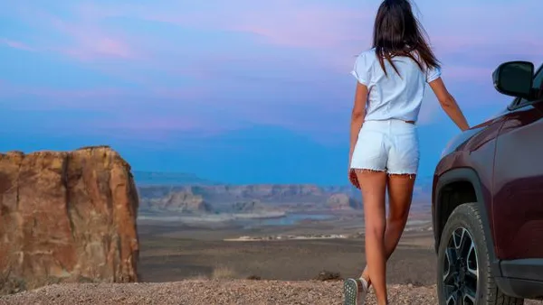 Young Brunette nurse in white summer casual outfit Posing on Off-Road Vehicle at Stud Horse Point, Page, Arizona.